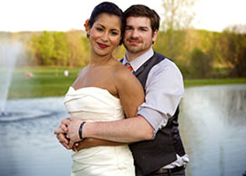 bride and groom posing in front of golf course